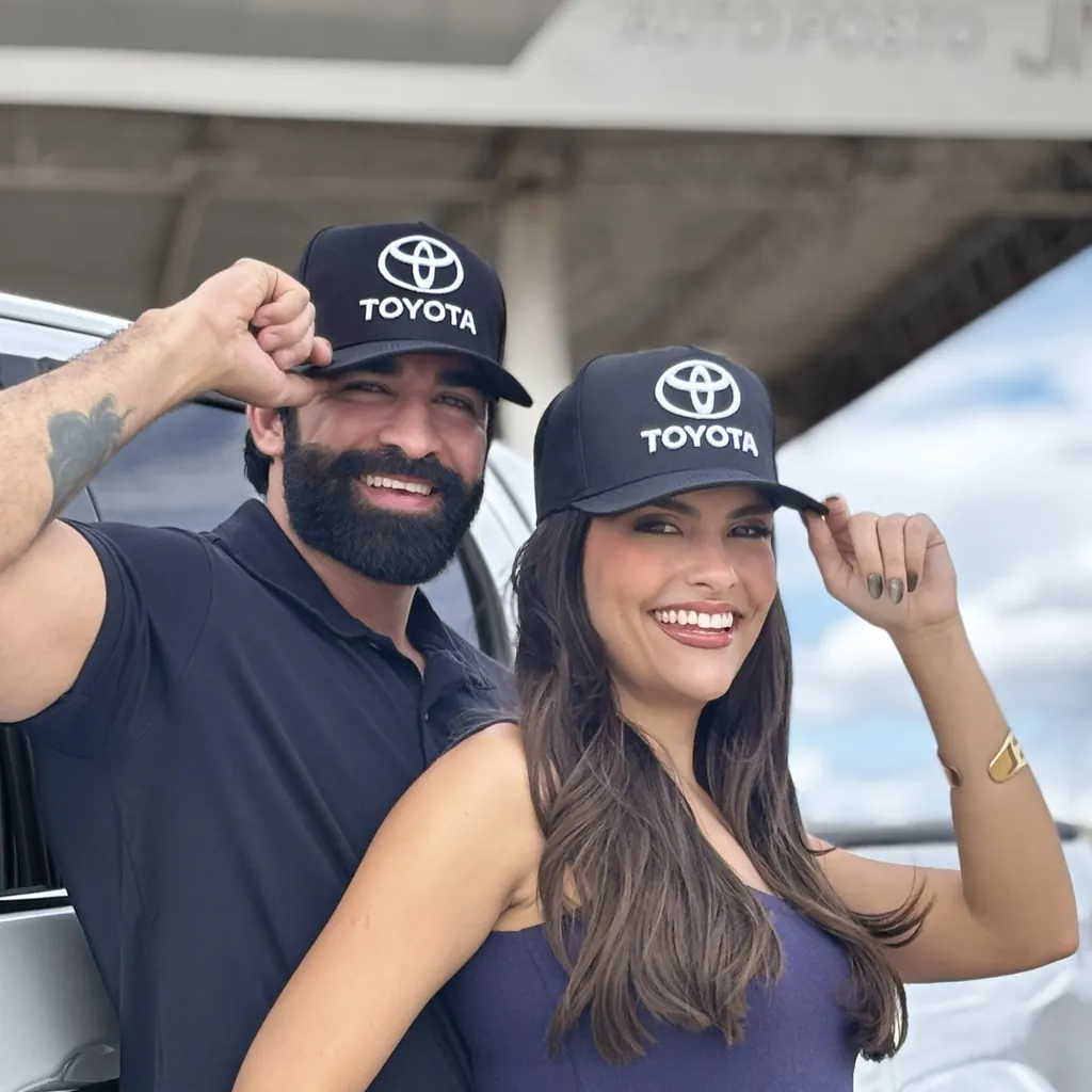 Casal usando bonés personalizados pretos com logo de empresa bordado