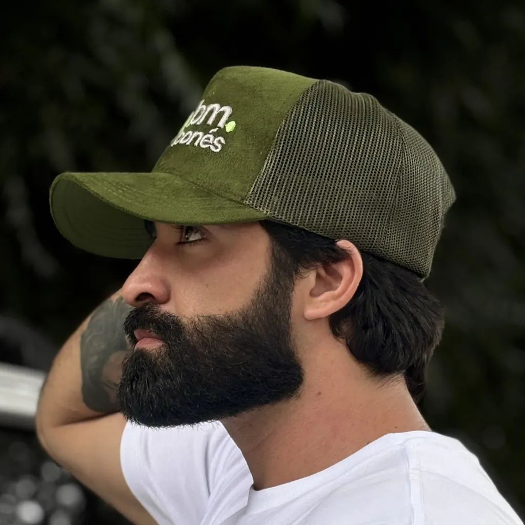 Homem de perfil usando boné trucker de camurça verde personalizado